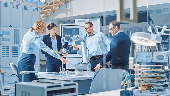 A team collaborating around a table with automated machinery on it