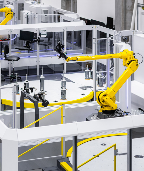 A robotic arm in cell inspecting parts on a turntable. 