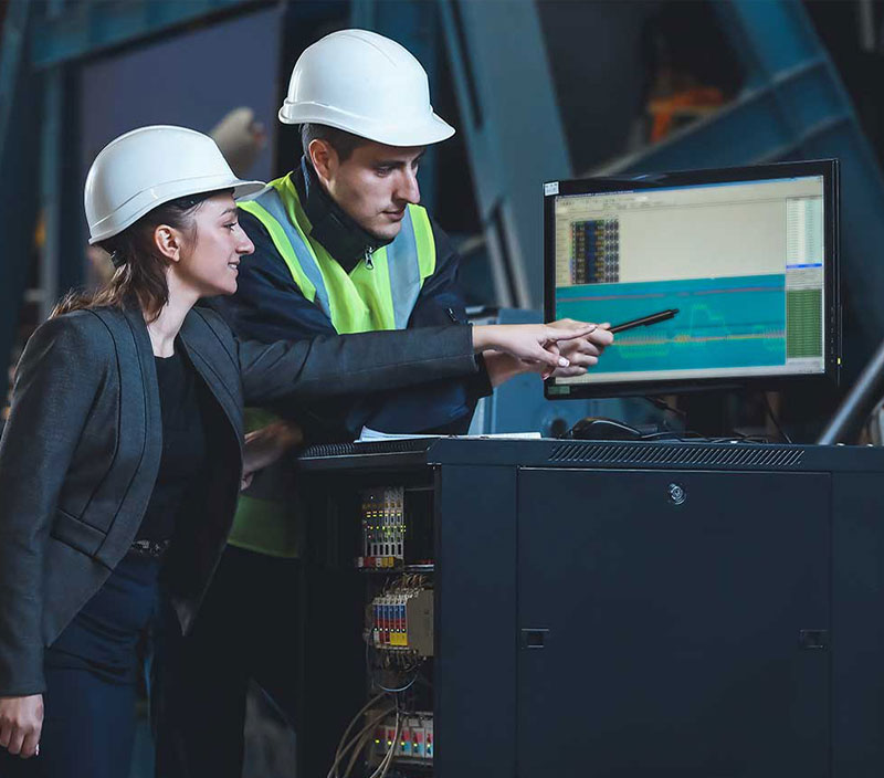 Image of two engineers evaluating downtime data on a laptop screen