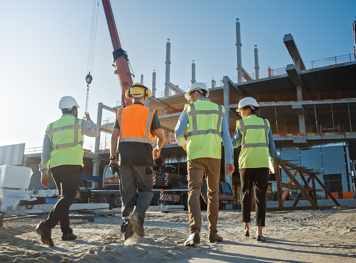 Workers wearing high visibility jackets and hard hats on a construction site.