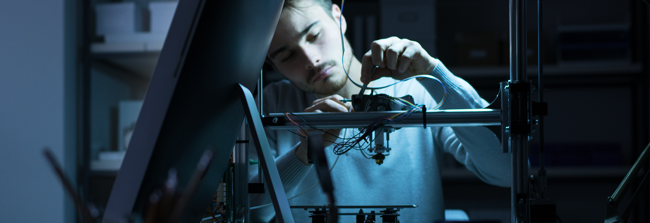 Operator working at a 3D printer to industrialise additive manufacturing