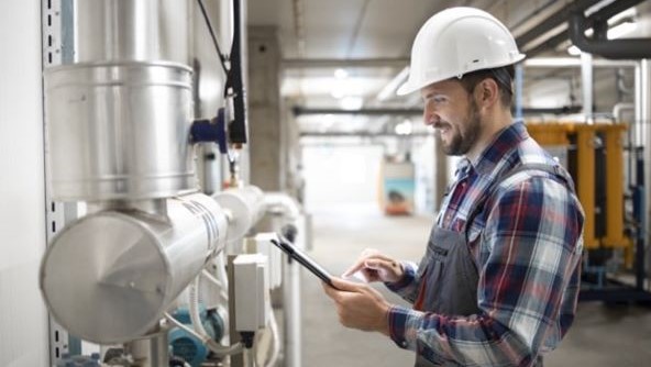 Man stood in front of machine with a tablet device