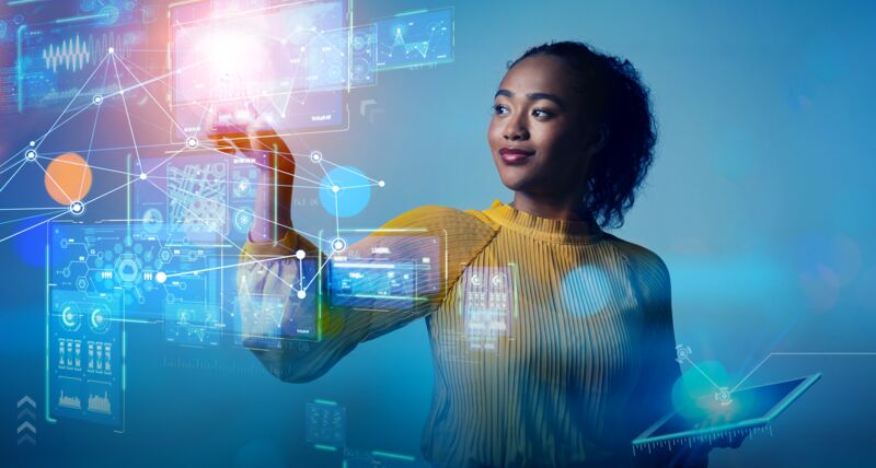 A woman holds a tablet displaying a digital interface, showcasing Nexus, Hexagon's innovative Digital Reality Platform.
