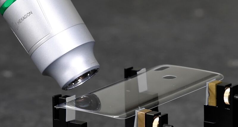 Chromatic white light scanner inspecting a mobile phone case mounted on a fixturing system