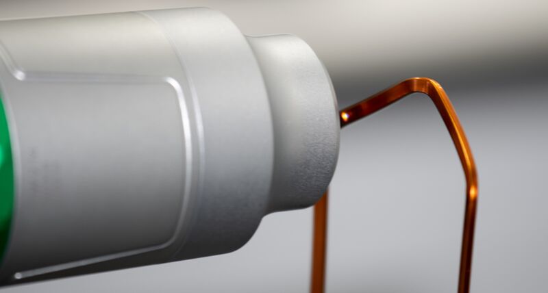 A close up of a non contact sensor inspecting a copper coloured wire HP-OW