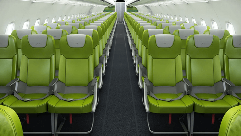 Image of airplane interior showing rows of green airplanes seats