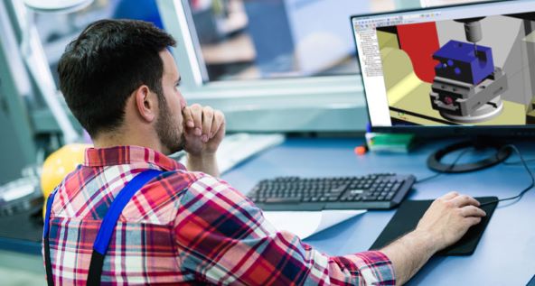 Engineer sitting at desk using a mouse while looking at software displayed on screen