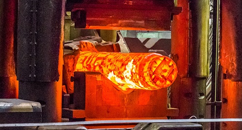 Steel ingot in hydraulic forging press.
