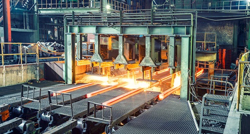 Hot steel on conveyor in steel plant.