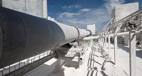 Calcium carbonate turning furnace with large pipe at cement plant.