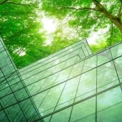 Image of glass building surrounded by green leafed trees