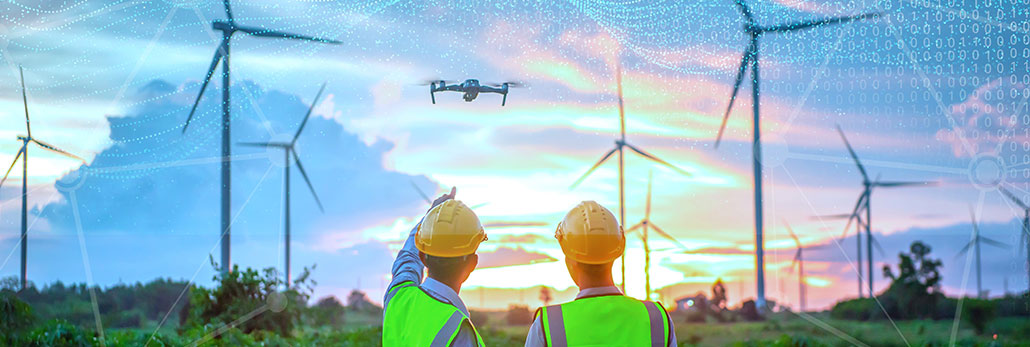 Engineers overlooking a windfarm whilst overlooking a wind farm