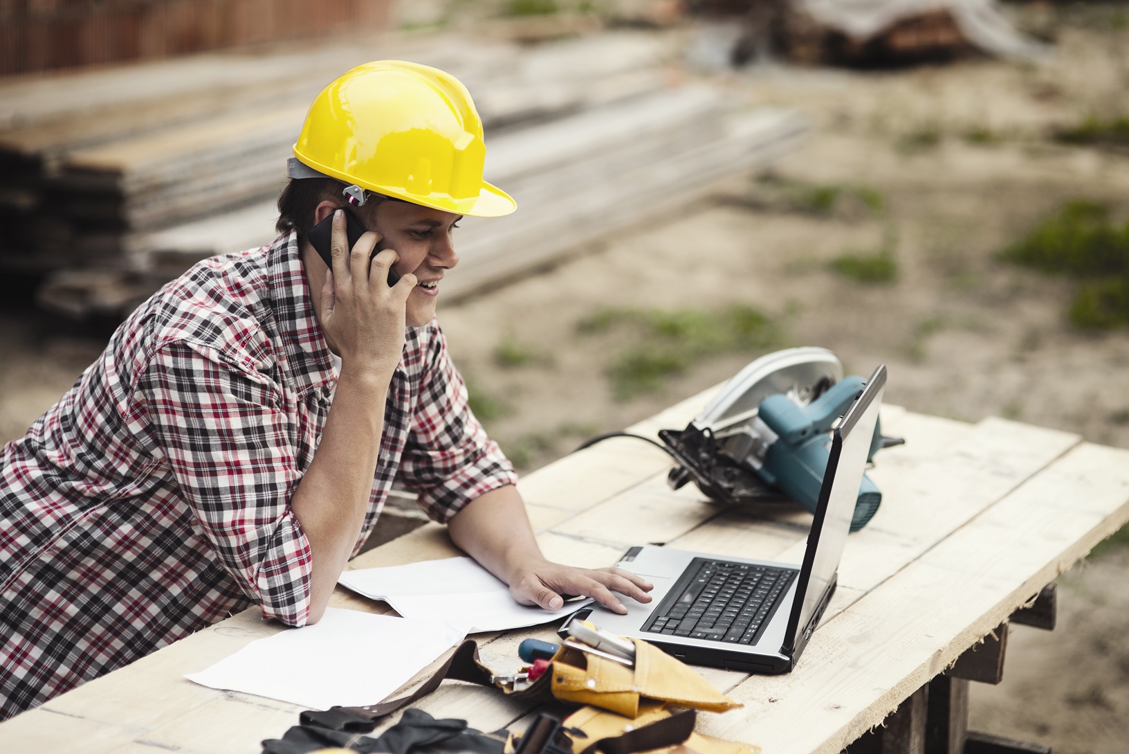 Construction worker on the job site using his mobile device to track construction tools and equipment, their location, usage and more via the tool tracking solution. 