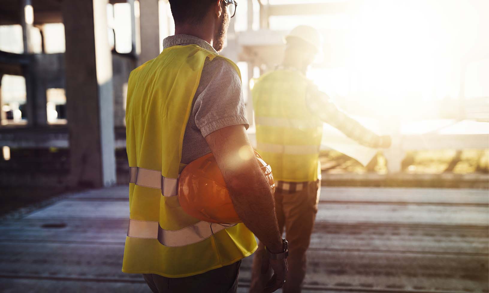 Construction workers wearing safety gear going over safety processes at the job site. 