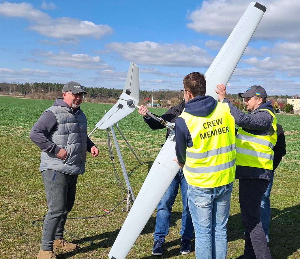 Three men preparing a UAV for flight