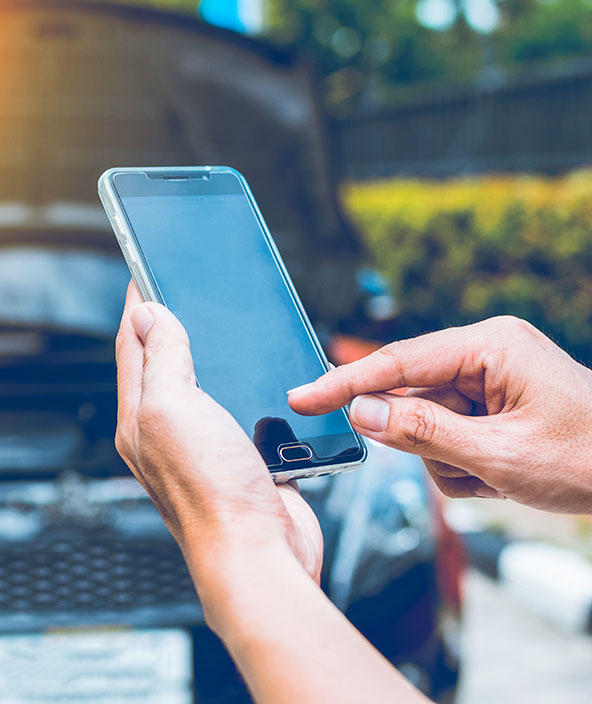 a person using a cell phone to contact roadside assistance