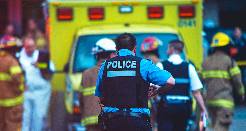 Police officer with paramedics and firefighters