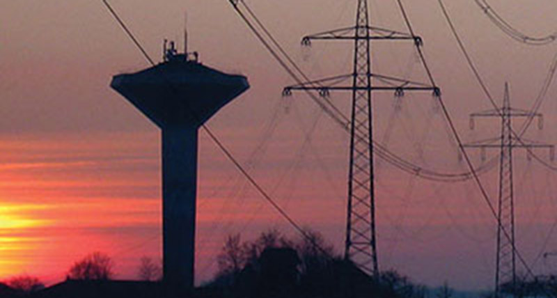 Bild von Stromleitungen vor einem leuchtenden Sonnenuntergang