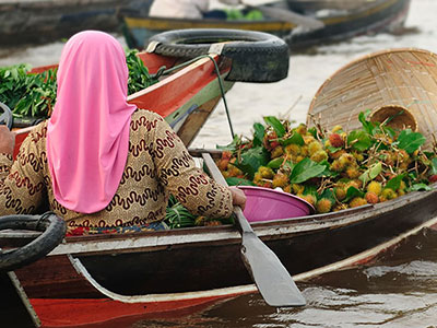 Young Indonesian girl transports goods across waterway