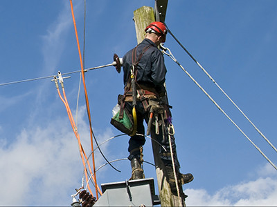 A maintenance worker fixes power lines using G/Technology