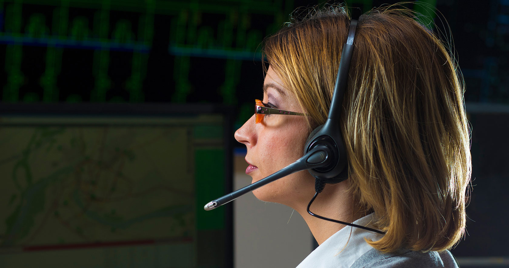 an emergency call dispatcher working at a computer
