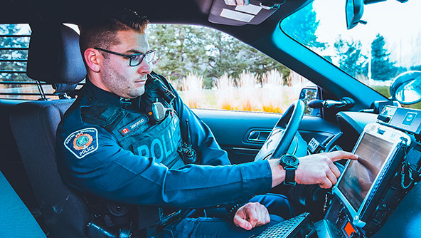 Police officer using their computer in their car