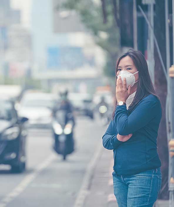 Femme portant un masque de protection dans une rue urbaine