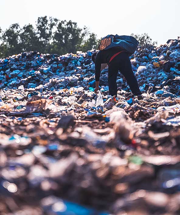 ゴミ捨て場で、リサイクルの概念であるリユース目的でペットボトルごみを回収するゴミ収集作業員。