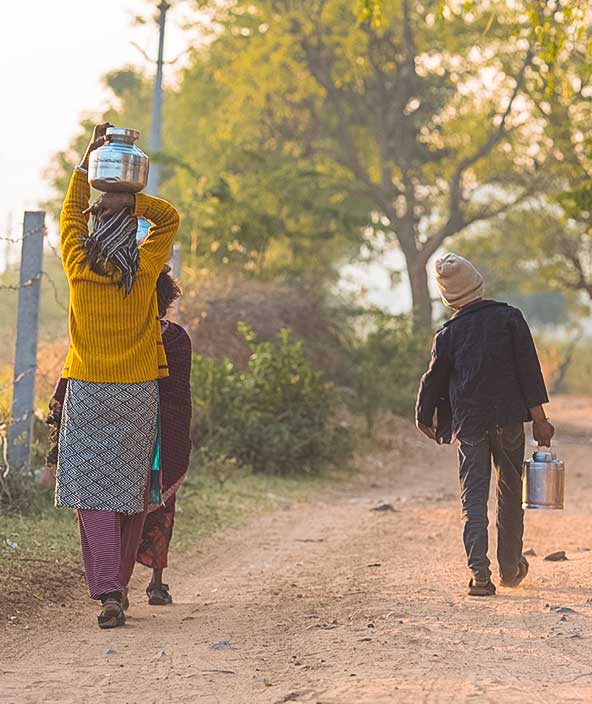 Children carrying water in a rural setting