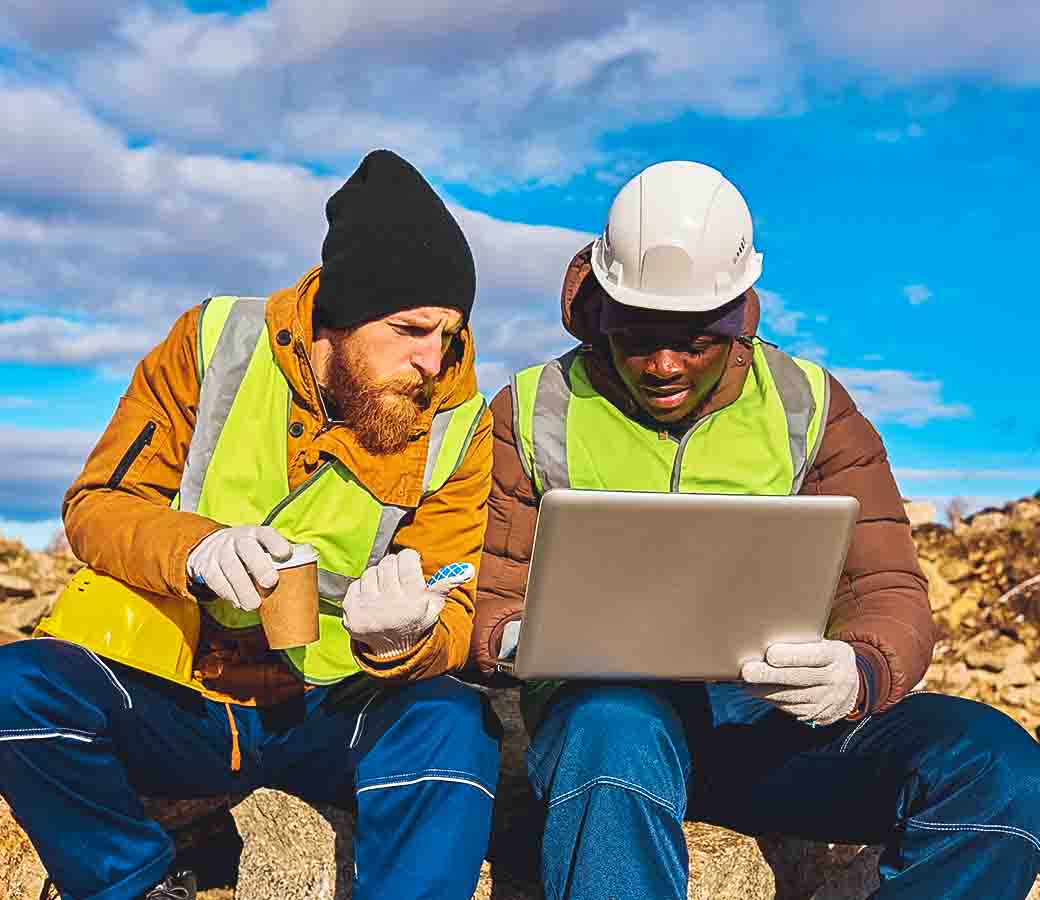 empleados de minas revisando información en un ordenador