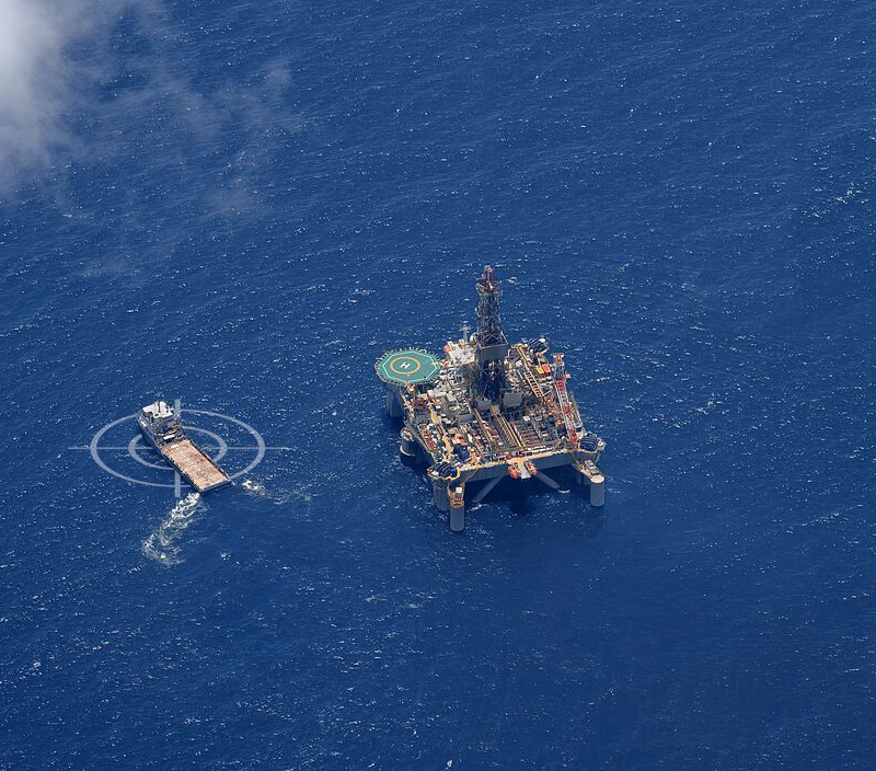 A ship and an offshore rig in the middle of the ocean. 