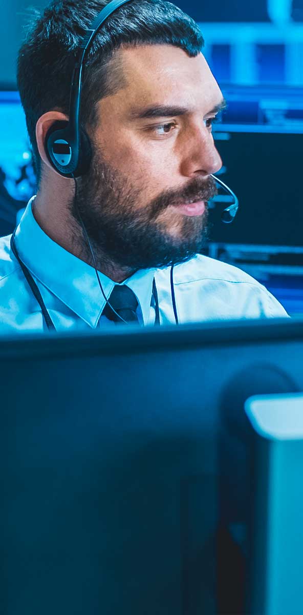 Man at computer console in emergency call center