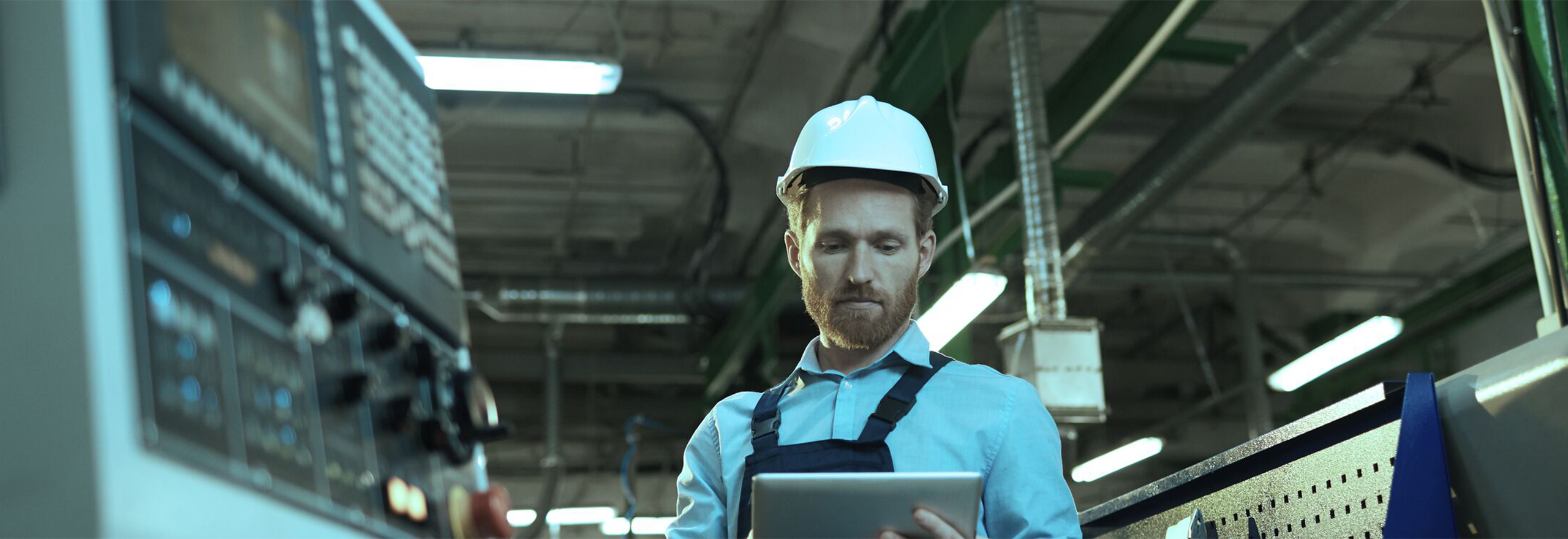Manufacturing worker using a tablet to add notes and details about a machine downtime event