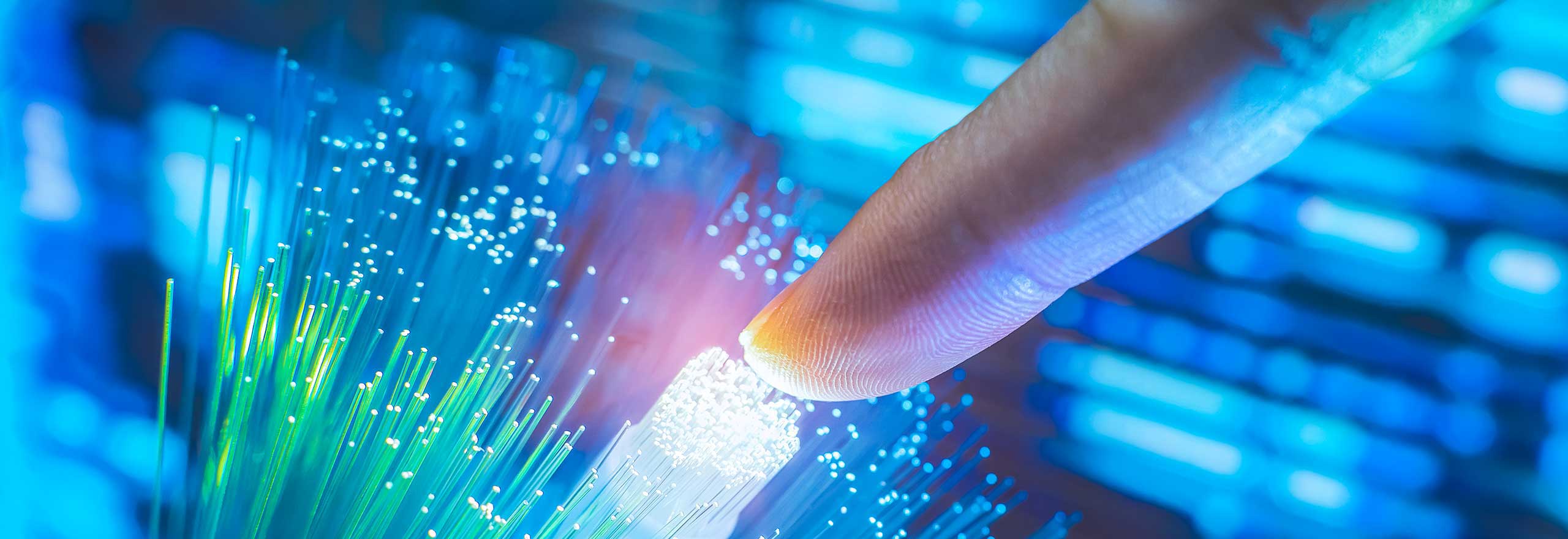 Finger touching a bundle of fibre optic cables