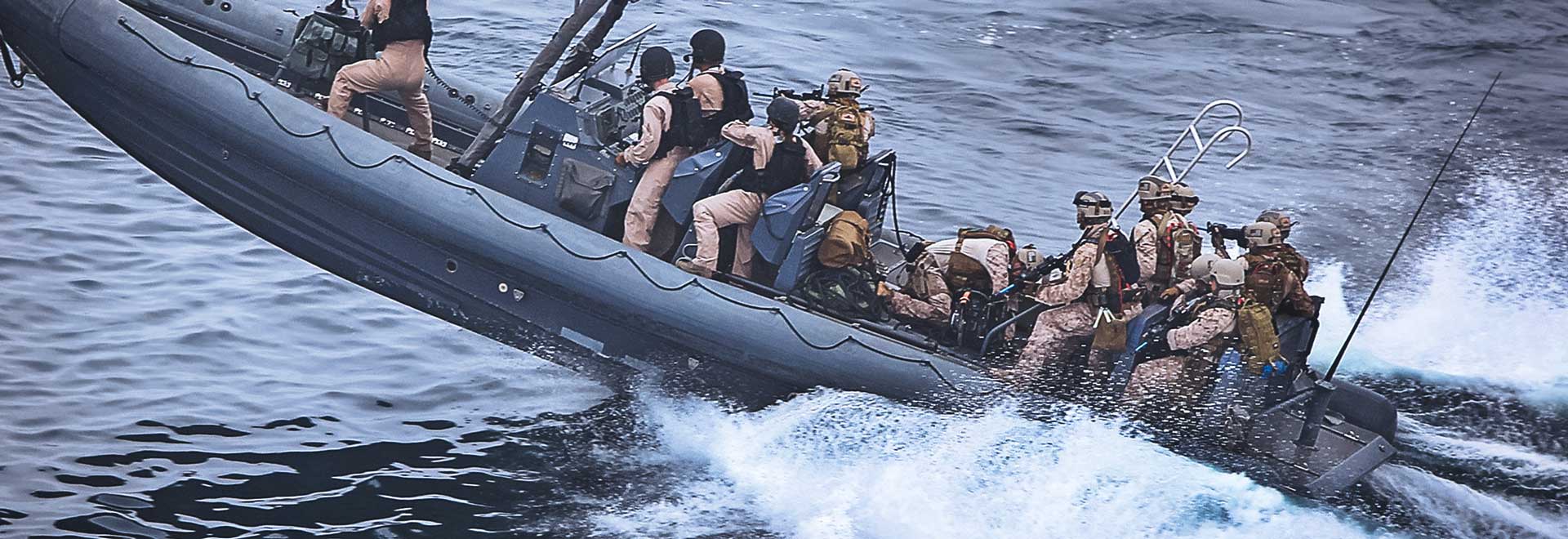 Marine-Matrosen auf Hochgeschwindigkeitsboot fahren zu einem Einsatz