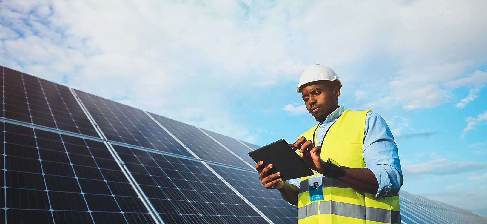 Gerente de operações verifica o status operacional atual de um parque de energia solar usando um tablet.