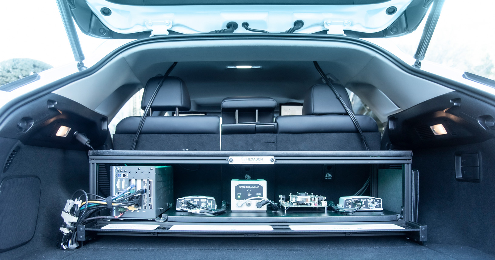 自律性運転を可能にするさまざまなハードウェアを表示するトランクが開かれたレクサス