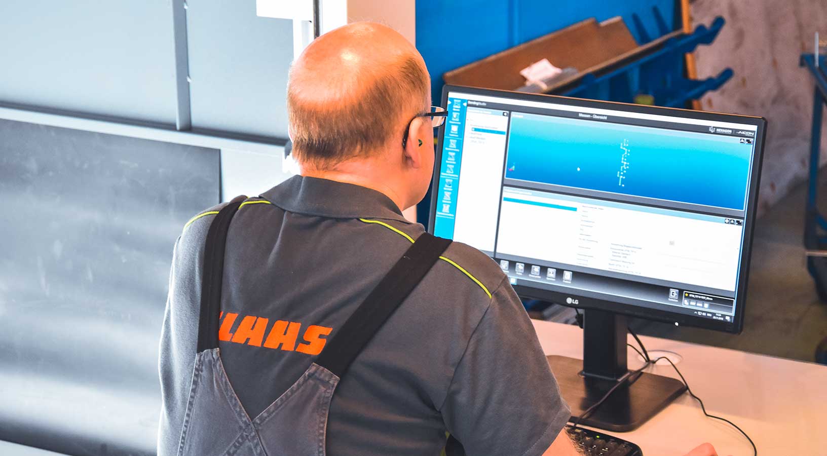 Empleado de OEM de equipos pesados en un ordenador usando un software de inspección 