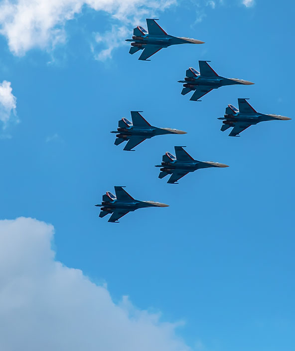 A formation of military aircraft soars through the sky